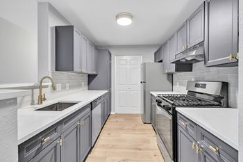 A kitchen with dark grey cabinets and a white counter top.